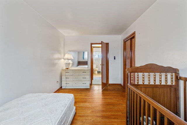 bedroom featuring light wood finished floors and baseboards