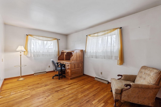 office area featuring light wood finished floors, baseboard heating, visible vents, and baseboards