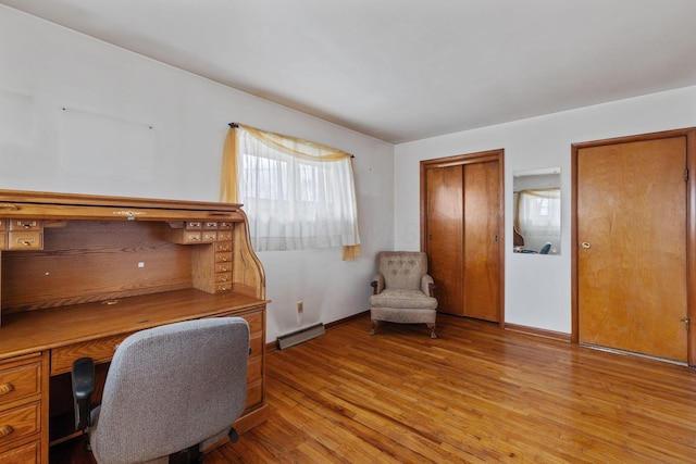 office space with light wood-style floors, baseboards, and visible vents