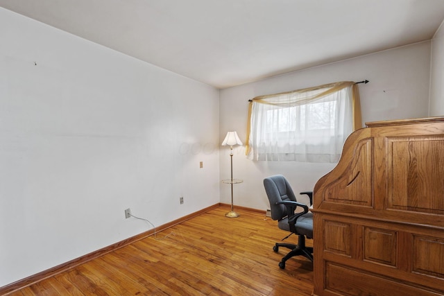 unfurnished office featuring light wood-style floors and baseboards