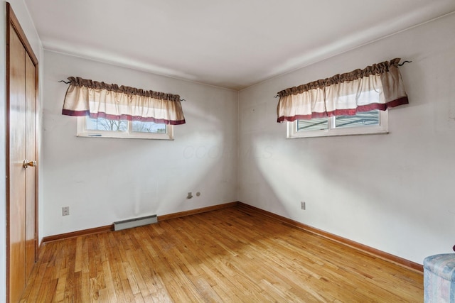 unfurnished room with light wood-type flooring, plenty of natural light, and baseboards