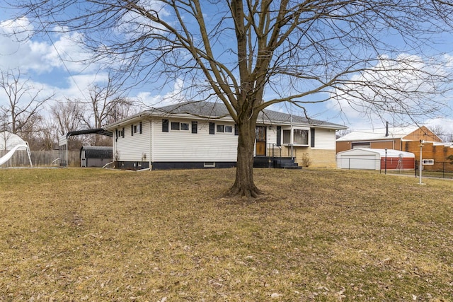 view of front of home with a garage, fence, a front lawn, and an outdoor structure