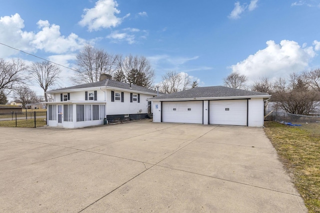 view of front facade featuring a garage, an outdoor structure, fence, a sunroom, and a chimney