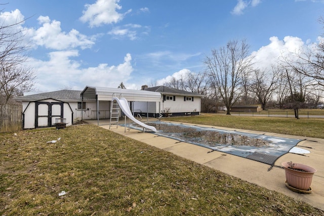 rear view of property with a fenced in pool, a lawn, an outbuilding, fence, and a patio area