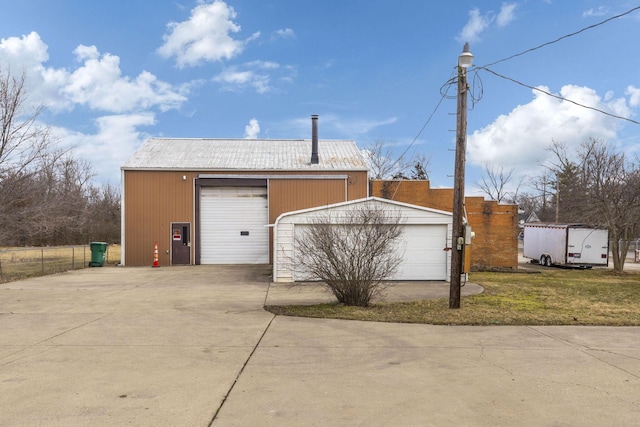 exterior space with a garage, an outbuilding, and fence