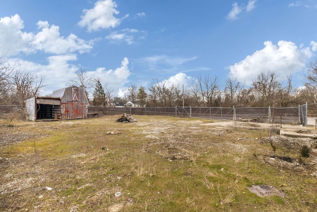 view of yard featuring a barn, fence, and an outdoor structure