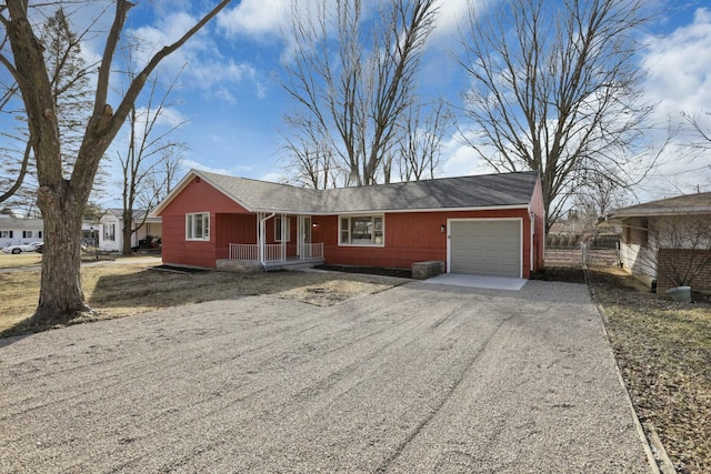 ranch-style house with a porch, driveway, and a garage