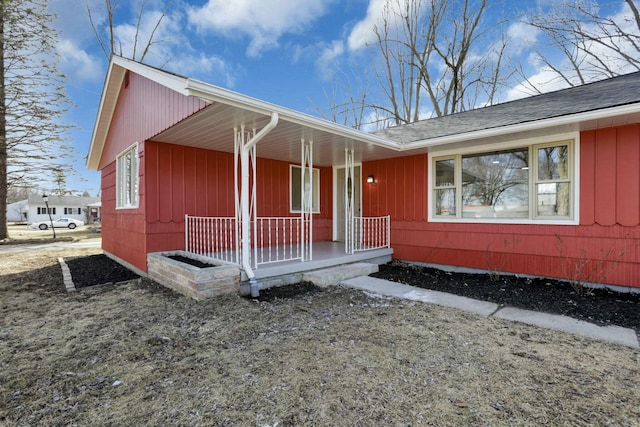 exterior space featuring covered porch and a shingled roof