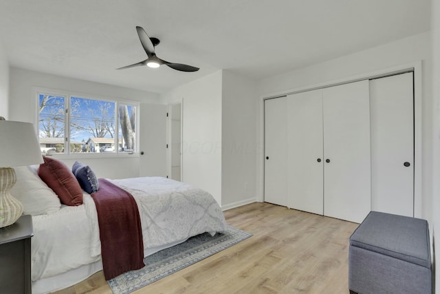 bedroom featuring a ceiling fan, a closet, and light wood-style flooring