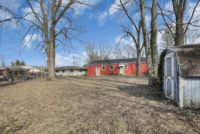 exterior space with a storage shed, fence, and an outbuilding