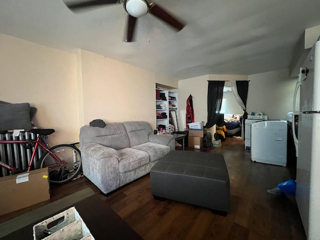 living room with a ceiling fan, washer and dryer, and wood finished floors