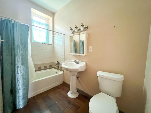 bathroom featuring toilet, shower / bath combination with curtain, baseboards, and wood finished floors