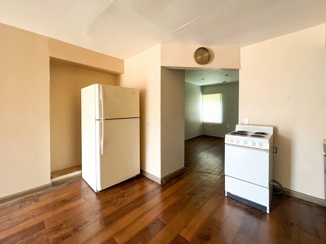 kitchen with white appliances, dark wood finished floors, and baseboards