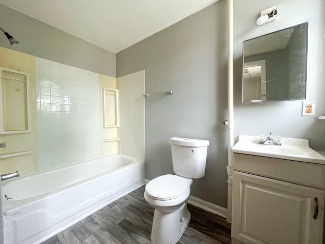 bathroom featuring baseboards, toilet, wood finished floors, vanity, and shower / bathing tub combination