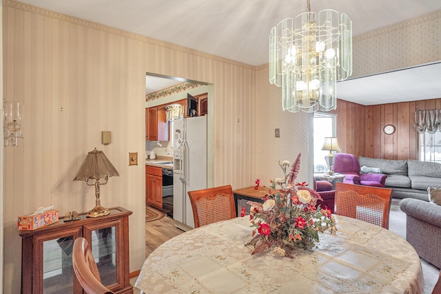 dining room with wallpapered walls and a notable chandelier