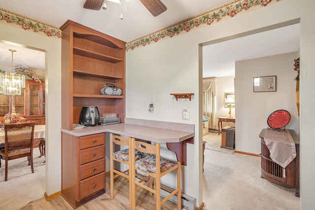 office space featuring light carpet, baseboards, and ceiling fan with notable chandelier