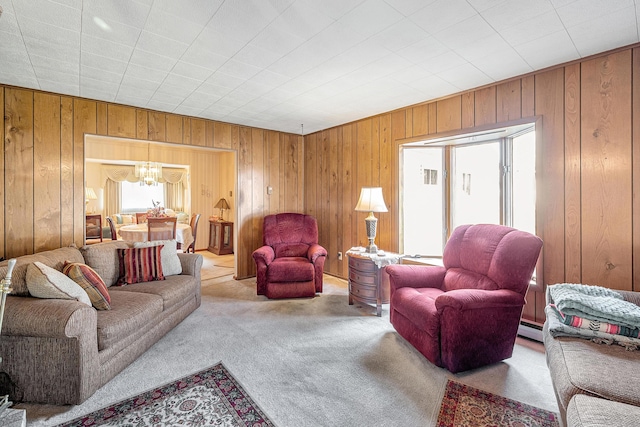 living area with a chandelier, carpet, wood walls, and baseboard heating