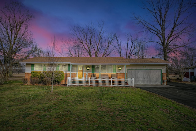 ranch-style home with an attached garage, aphalt driveway, a porch, and brick siding