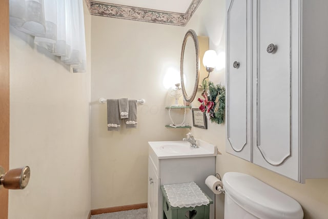 half bath featuring toilet, baseboards, and vanity