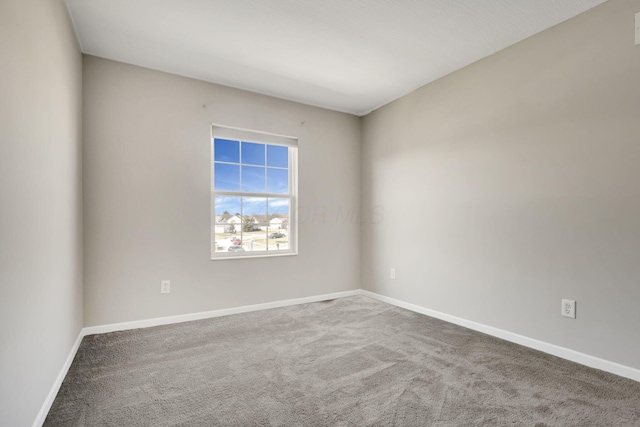 empty room featuring carpet flooring and baseboards