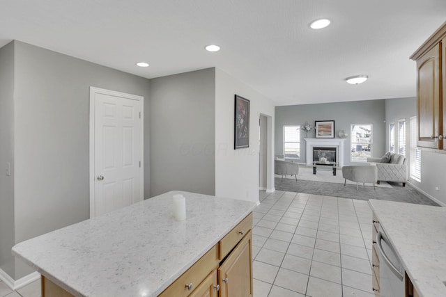 kitchen featuring dishwashing machine, baseboards, a glass covered fireplace, open floor plan, and a center island