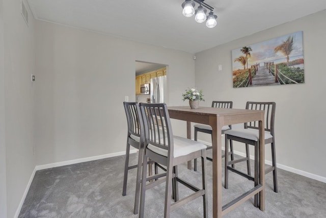 dining space with visible vents, light colored carpet, and baseboards