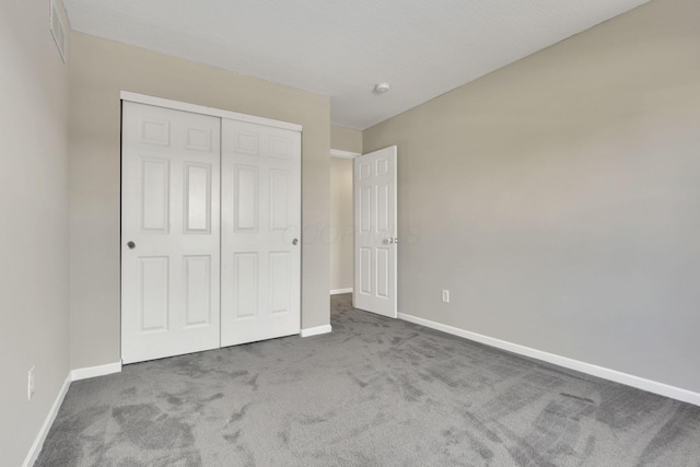 unfurnished bedroom featuring a closet, visible vents, baseboards, and carpet floors