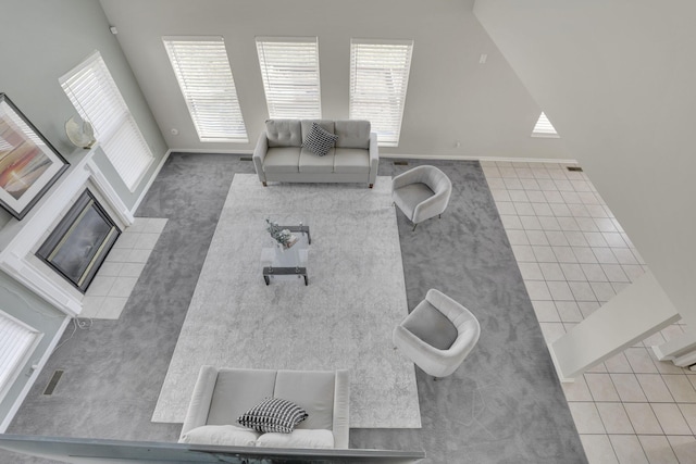 living area featuring tile patterned floors and a fireplace with flush hearth