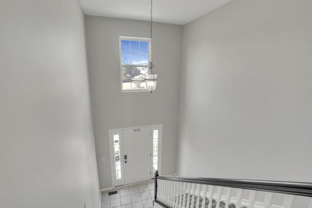 foyer featuring light tile patterned floors and a chandelier