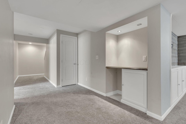 interior space with built in study area, baseboards, and carpet floors