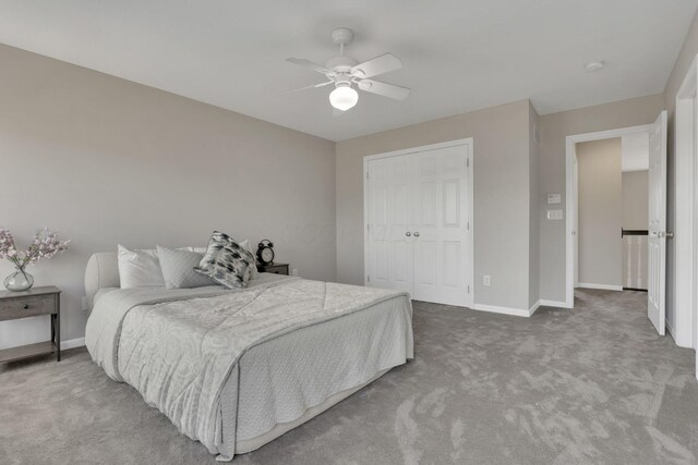 bedroom with ceiling fan, carpet, a closet, and baseboards