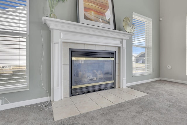 room details with a tiled fireplace, carpet flooring, and baseboards