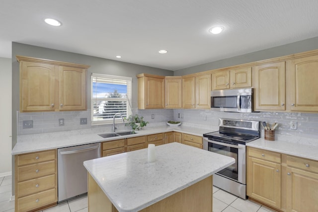 kitchen with recessed lighting, a sink, light brown cabinetry, stainless steel appliances, and a center island