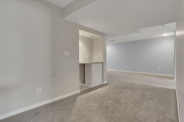 spare room with light colored carpet and baseboards