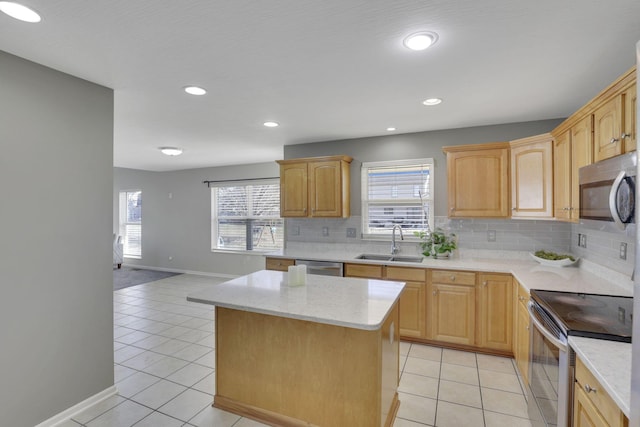 kitchen featuring light tile patterned flooring, appliances with stainless steel finishes, a center island, and a sink