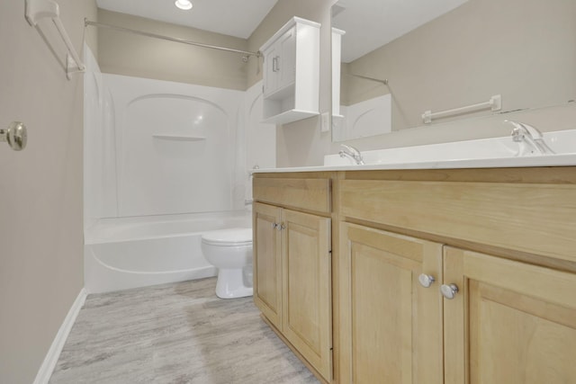 bathroom with vanity, wood finished floors, baseboards, toilet, and shower / bathtub combination