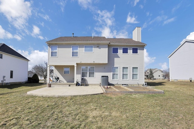 rear view of house featuring a yard, a patio, central AC unit, and a chimney