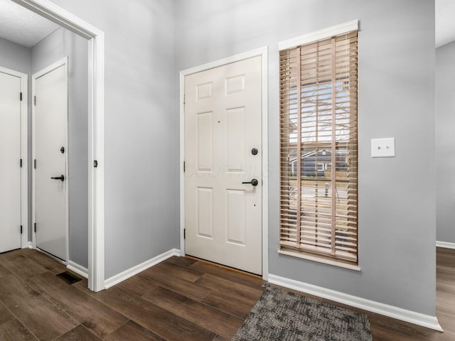 entryway with wood finished floors, visible vents, and baseboards