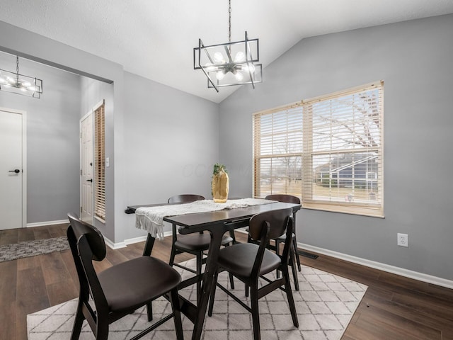 dining space with visible vents, baseboards, wood finished floors, an inviting chandelier, and vaulted ceiling