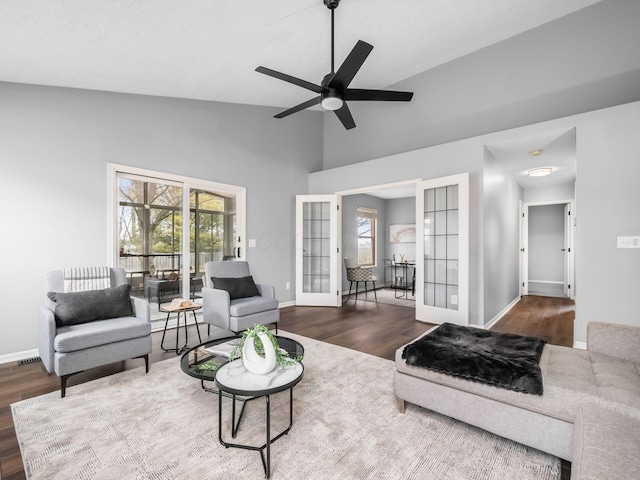 living area featuring baseboards, ceiling fan, wood finished floors, vaulted ceiling, and french doors