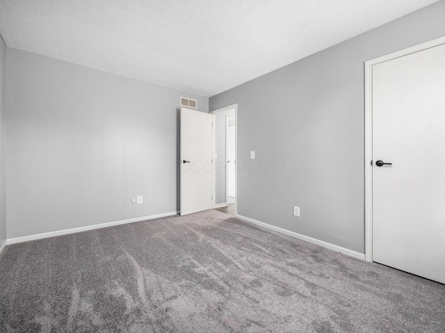 unfurnished bedroom with carpet floors, baseboards, visible vents, and a textured ceiling