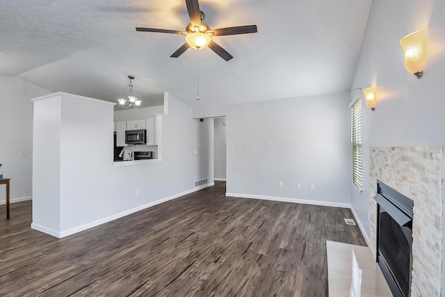 unfurnished living room with baseboards, visible vents, dark wood finished floors, vaulted ceiling, and a fireplace