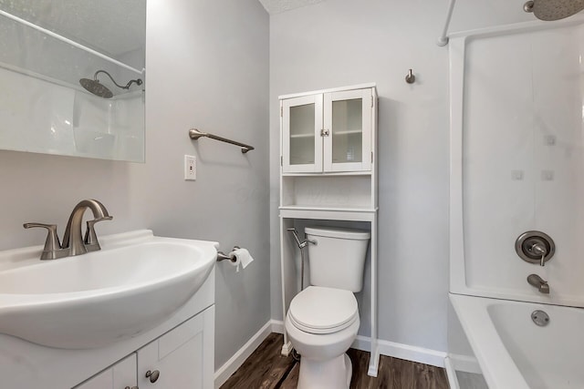 full bathroom featuring baseboards, toilet, wood finished floors, vanity, and shower / washtub combination