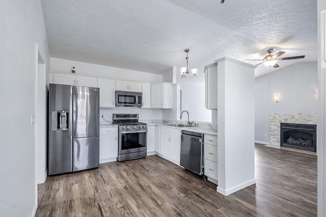 kitchen with stainless steel appliances, dark wood-style flooring, a sink, and light countertops