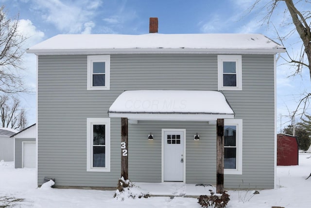 view of front facade with an outdoor structure and a chimney