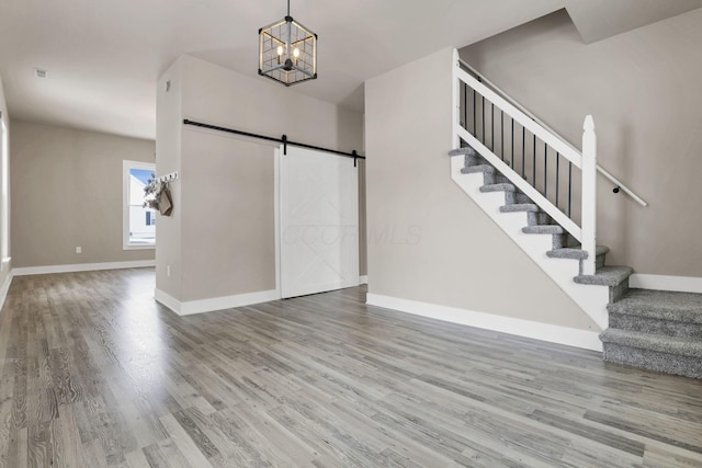 32 Railroad St, Jeffersonville, OH 43128 - foyer entrance featuring a barn door, stairway, wood finished floors, baseboards, and a chandelier