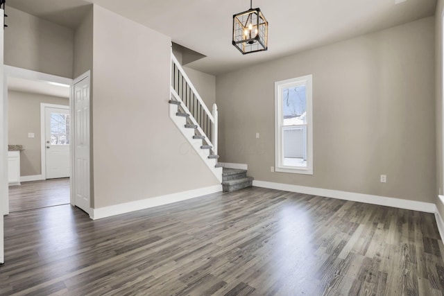 32 Railroad St, Jeffersonville, OH 43128 - unfurnished living room with a chandelier, dark wood-style flooring, stairway, and baseboards