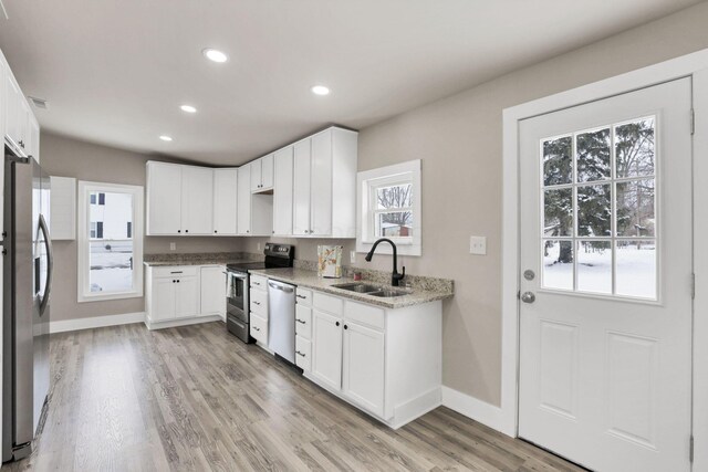 32 Railroad St, Jeffersonville, OH 43128 - kitchen featuring appliances with stainless steel finishes, a sink, plenty of natural light, recessed lighting, and light wood-style flooring