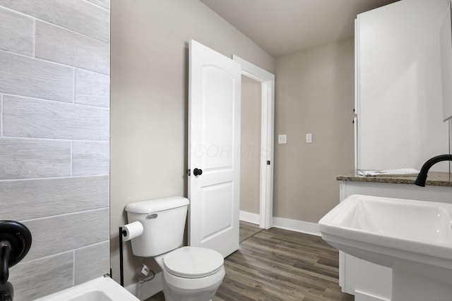 32 Railroad St, Jeffersonville, OH 43128 - full bath featuring wood finished floors, toilet, baseboards, and a sink