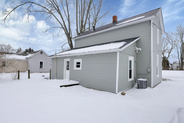 32 Railroad St, Jeffersonville, OH 43128 - snow covered property featuring central AC, a chimney, and metal roof